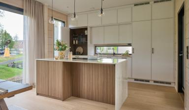 Moderni_vaalea_valkoinen_i-keittiö_saarekekeittiö_Hirsi_Kastelli_19